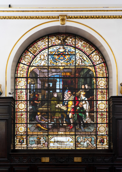 Stained glass window as described in the main text. The setting of the window shows the wood panelling and gilded plasterwork at Stationers' Hall.