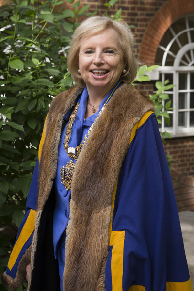 Photograph of a woman in ceremonial robe and chain standing in the garden of Stationers' Hall.