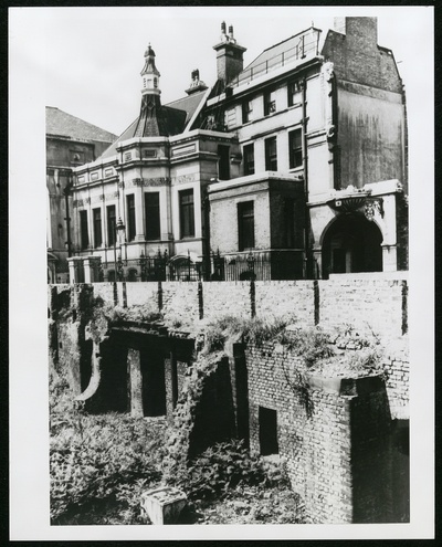 The photograph shows a bomb crater right in front of Stationers' Hall, exposing the foundations of the building.