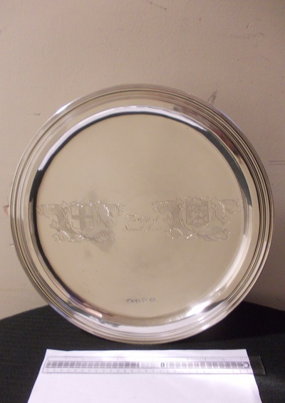A silver dish. the slightly raised rim with moulded border raised on a trumpet foot, the centre engraved with a Coat of Arms of the Mearn family and that of the Company, also engraved 'The Gift of Samuel Mearn.' Indented are the hallmark and the maker's mark of the silversmith, Robert Cooper.